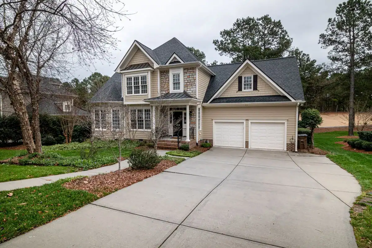 A charming suburban home with a two-car garage and a manicured lawn, highlighting quality local craftsmanship.
