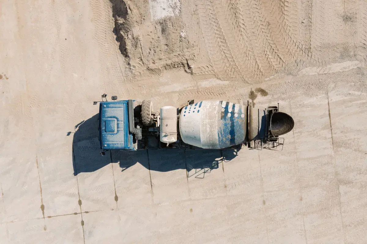 A concrete mixer truck at a construction site, illustrating the costs involved in concrete projects.